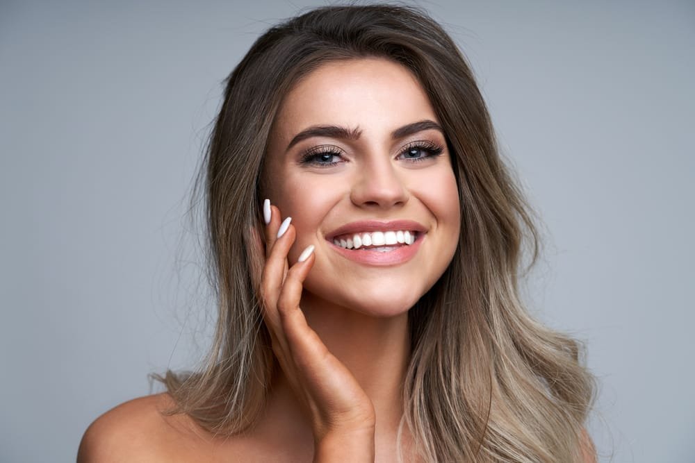 Beautiful adult woman portrait. Studio shot, isolated on white background Radiesse®